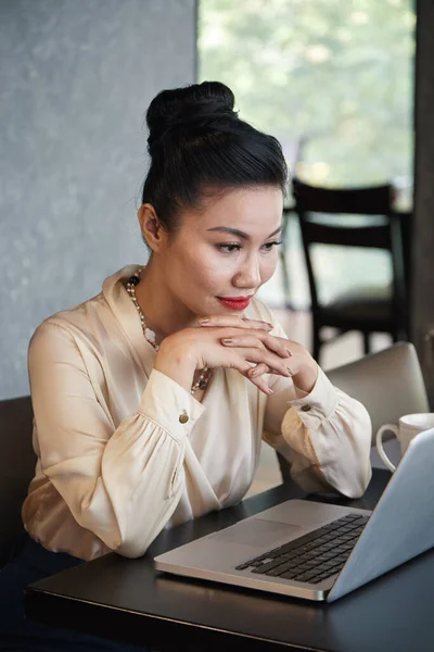 Geschäftsfrau liest Artikel auf Laptop — Stockfoto