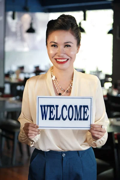 Restaurant Owner holding Welcome Sign
