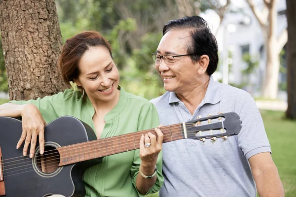 Yaşlı kadın kocası için gitar çalıyor. — Stok fotoğraf