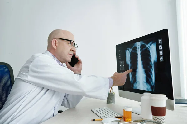 Médico examinando imagen de rayos X en la oficina — Foto de Stock