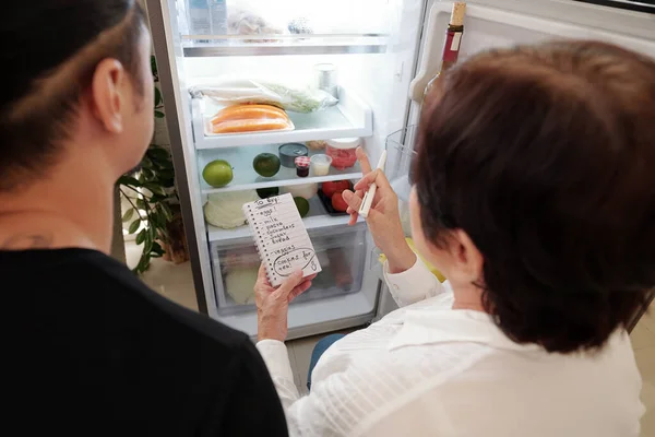 Mère faisant la liste des courses pour son fils — Photo