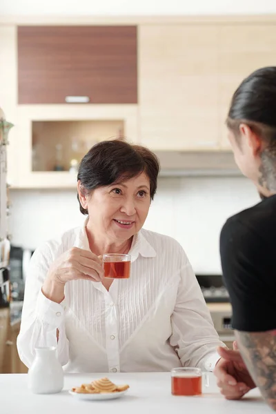 Woman drinking tea with her son — Stock Fotó