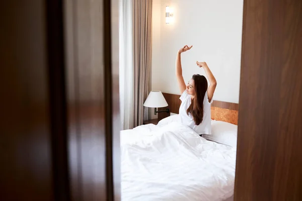 Giovane donna che si estende a letto — Foto Stock