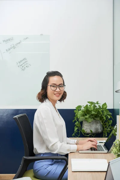 Mujer de negocios sonriente que trabaja en el ordenador portátil —  Fotos de Stock