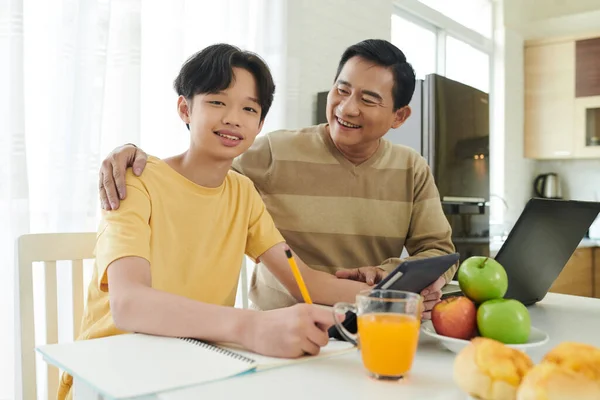 Stolzer Vater blickt auf studierenden Sohn — Stockfoto