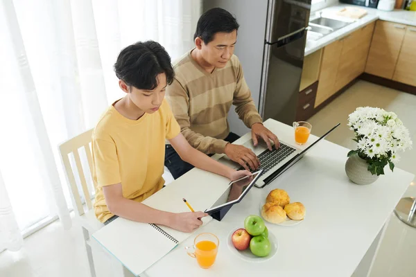 Father Working next to Studying Son — Stock Photo, Image