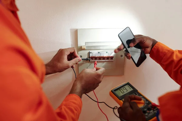 Técnicos testando corrente elétrica — Fotografia de Stock