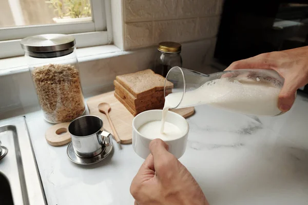 Homme versant du lait dans une tasse de café — Photo