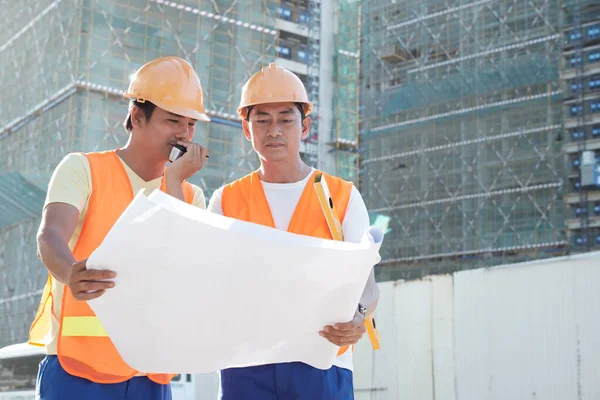 Bauunternehmer im Gespräch mit Bauherren per Walkie-Talkie — Stockfoto