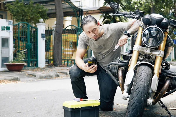 Homem tentando reparar motocicleta — Fotografia de Stock