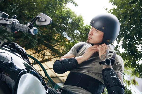 Hombre poniéndose el casco para la protección —  Fotos de Stock