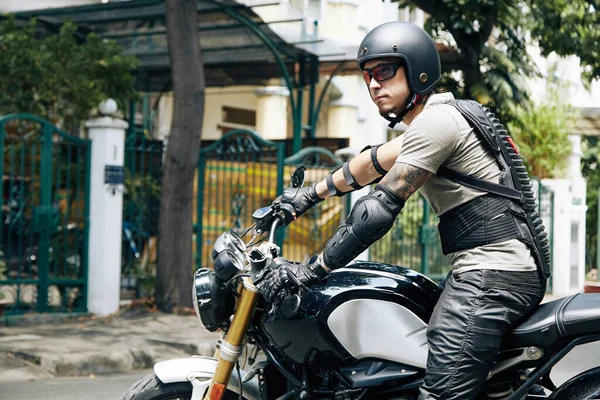 Man met beschermend vistuig zittend op motorfiets — Stockfoto