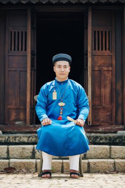 Tapınağın önünde oturan adam.