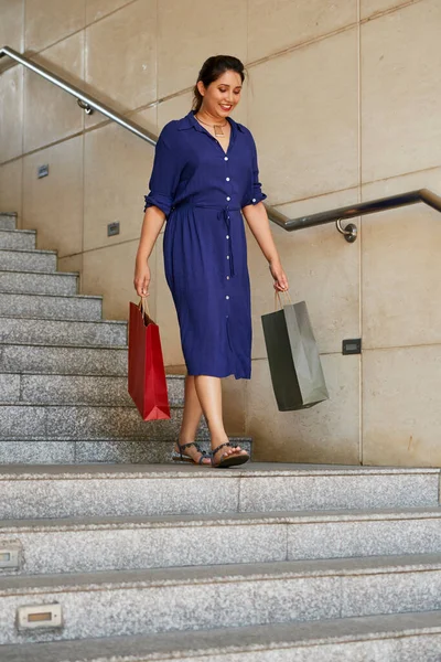 Woman with Shopping Bags Walking Down Stairs — Stock Photo, Image