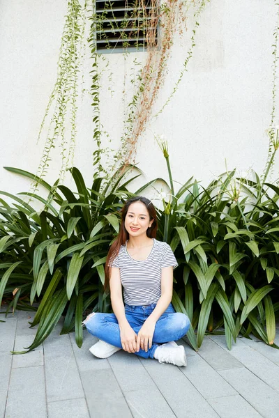 Mujer sonriente sentada en el suelo — Foto de Stock