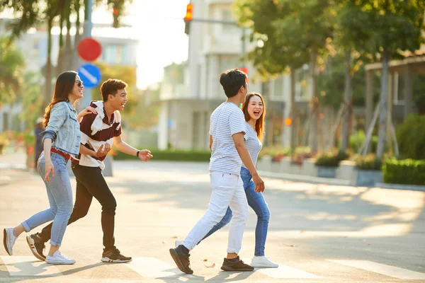 Jóvenes alegres cruzando la calle — Foto de Stock