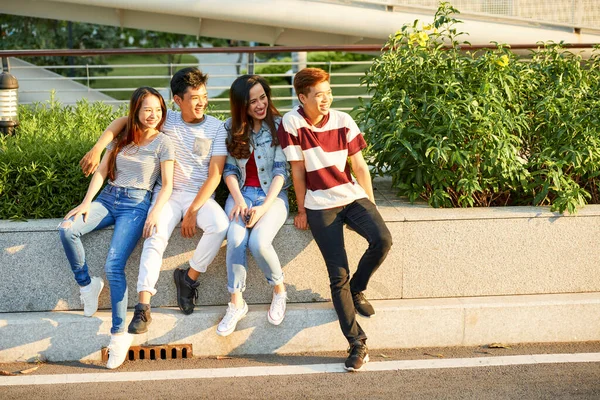 Groep van gelukkige vrienden zitten buiten — Stockfoto