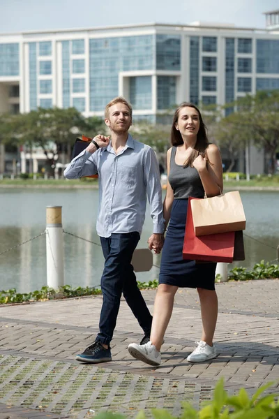 Novio y novia enamorados llevando bolsas de compras — Foto de Stock