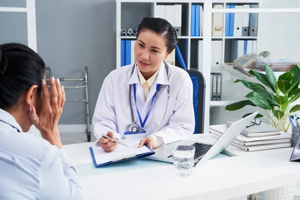 Doctora hablando con paciente con dolor de cabeza —  Fotos de Stock