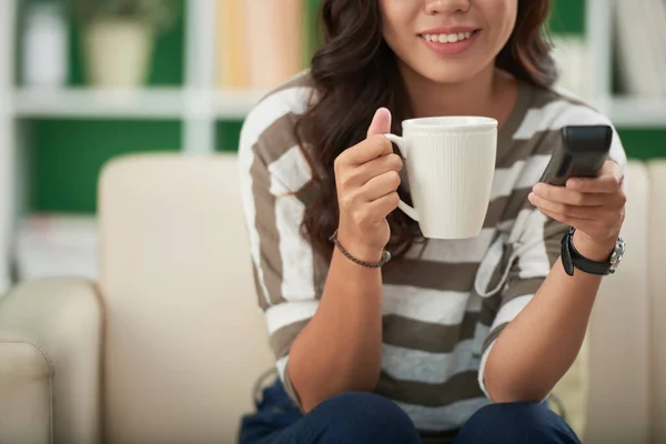 Kvinnan tittar på nyheter och dricka kaffe — Stockfoto