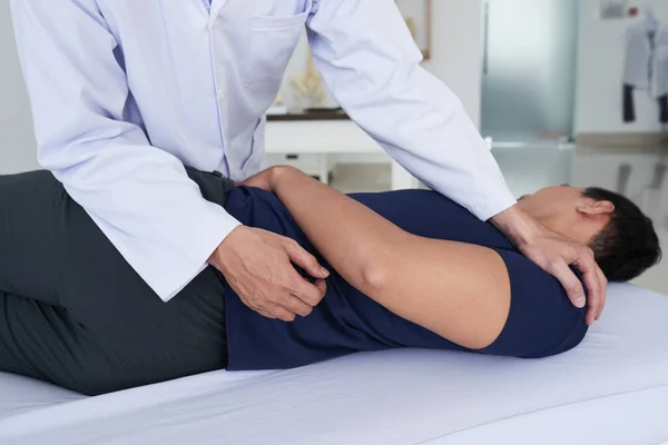 Physiotherapeut arbeitet mit Patient in Klinik — Stockfoto