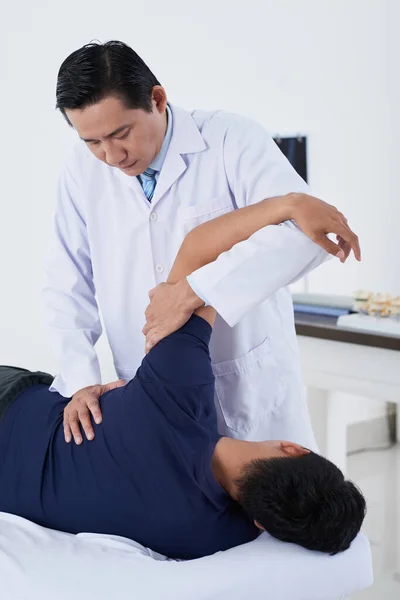 Азиатский врач на работе с пациентом — стоковое фото