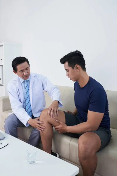 Traumatoloog Palpating Knie van de patiënt — Stockfoto