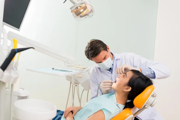 Dentist treating female patient — Stock Photo, Image