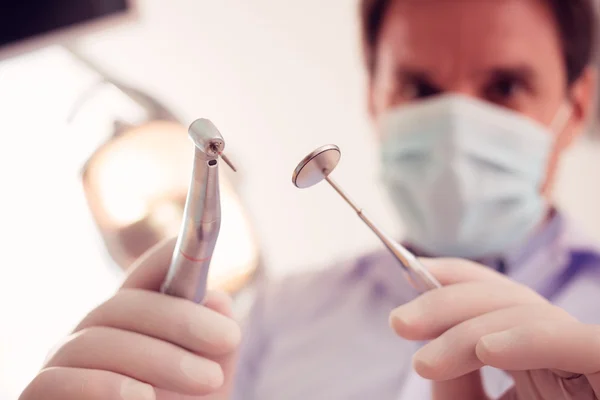 Estomatólogo sosteniendo herramientas dentales — Foto de Stock