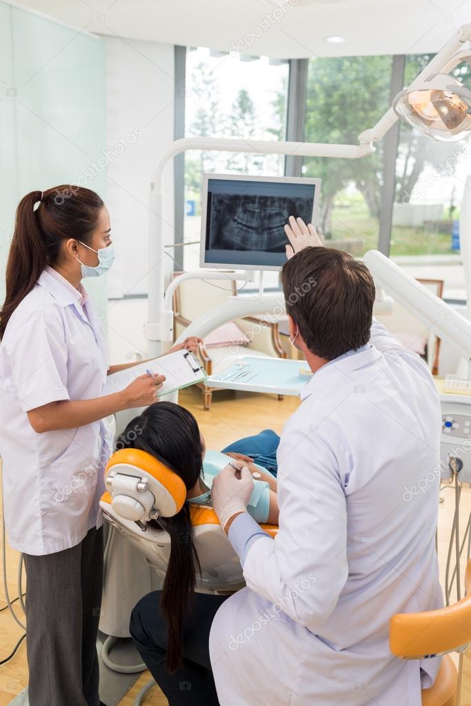 Dentist showing a patient x-ray of teeth