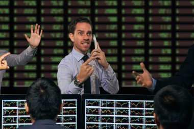 Trader gesturing at stock exchange