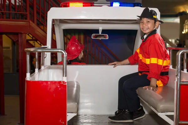 Little firefighters in the fire truck — Stock Photo, Image