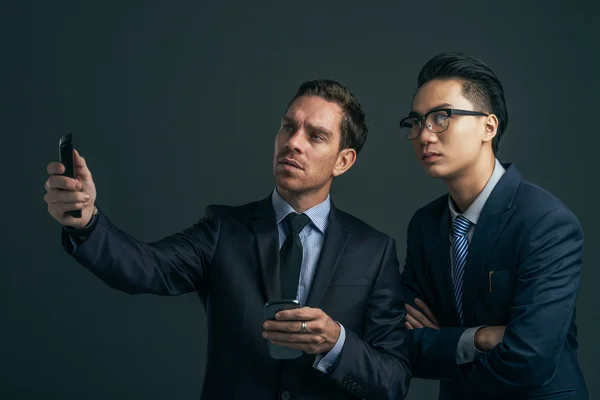 Business colleagues using smartphones — Stock Photo, Image