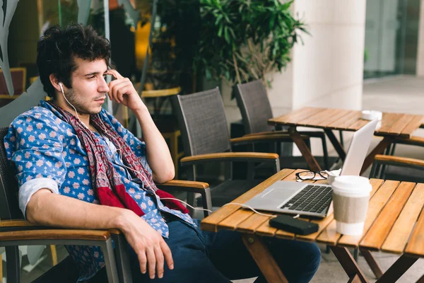 Homme dans les écouteurs regarder le film sur l'ordinateur portable — Photo