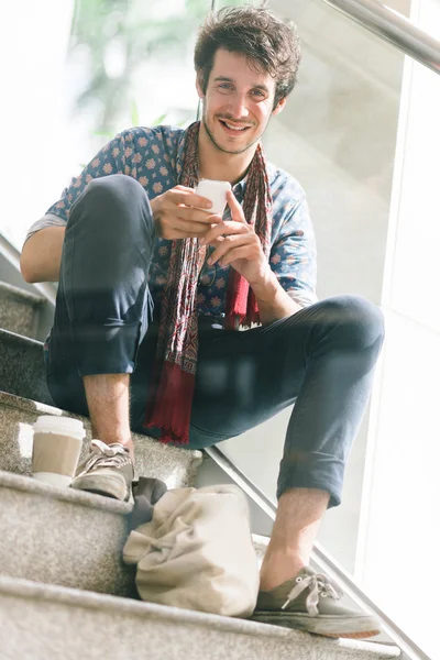 Young man sitting on the steps — Stock Photo, Image