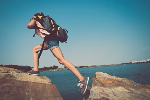 Toeristische met rugzak een rots klimmen — Stockfoto