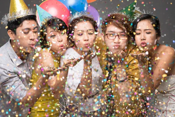 People blowing confetti in the air Stock Image