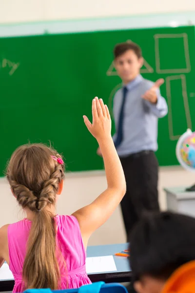 Девушка поднимает руку в классе — стоковое фото