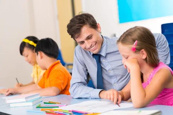 Enseignant de l'école primaire aider l'élève — Photo