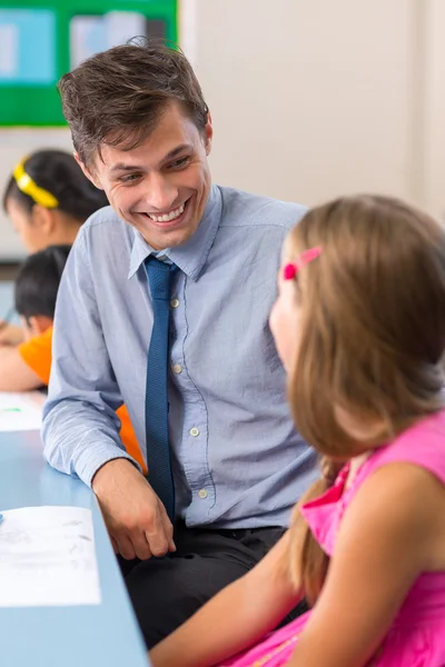 Junger Lehrer im Gespräch mit seinem Schüler — Stockfoto