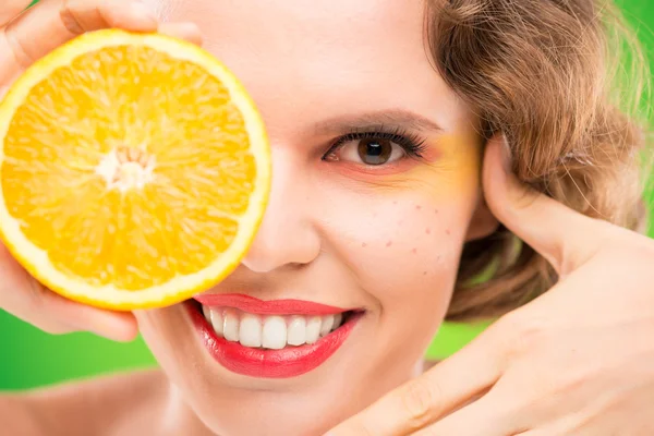 Mujer sosteniendo media naranja —  Fotos de Stock