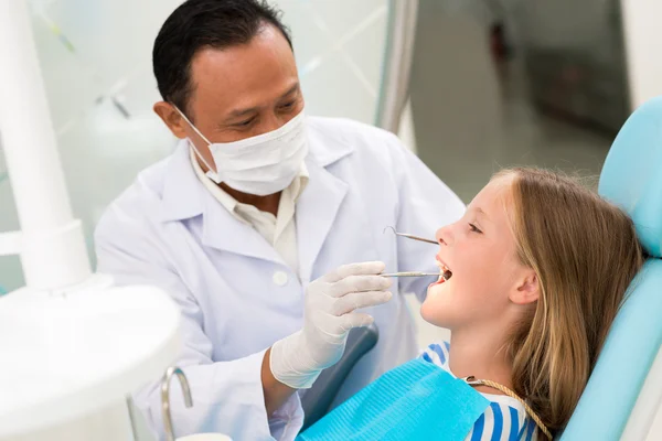 Maduro ásia dentista examinando um menina — Fotografia de Stock