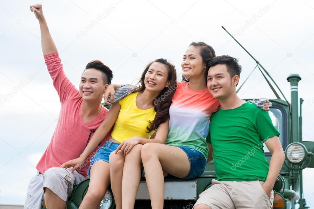 Cheerful Asian young people on the car