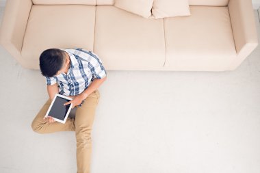 Evde tablet kullanan adam