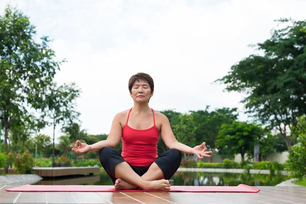 Senior Japanese woman practicing yoga — Stock Photo, Image