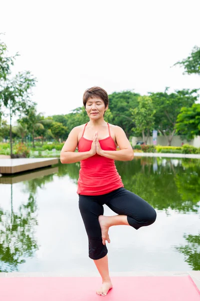 Mujer mayor de pie en pose de yoga —  Fotos de Stock