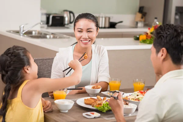 Little girl feeding her mother — Stock Photo, Image