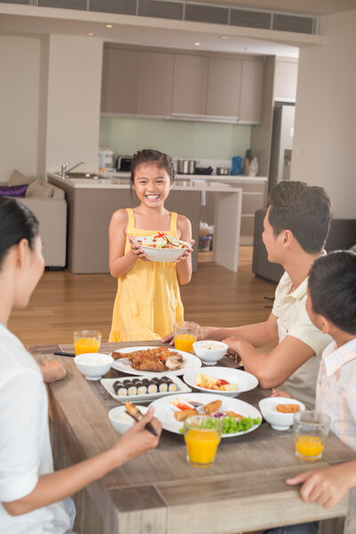 Happy girl bringing bowl of salad
