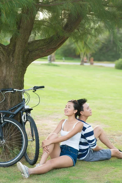 Jovem casal relaxante depois de andar de bicicleta — Fotografia de Stock