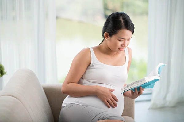 Junge schwangere Frau liest Buch — Stockfoto